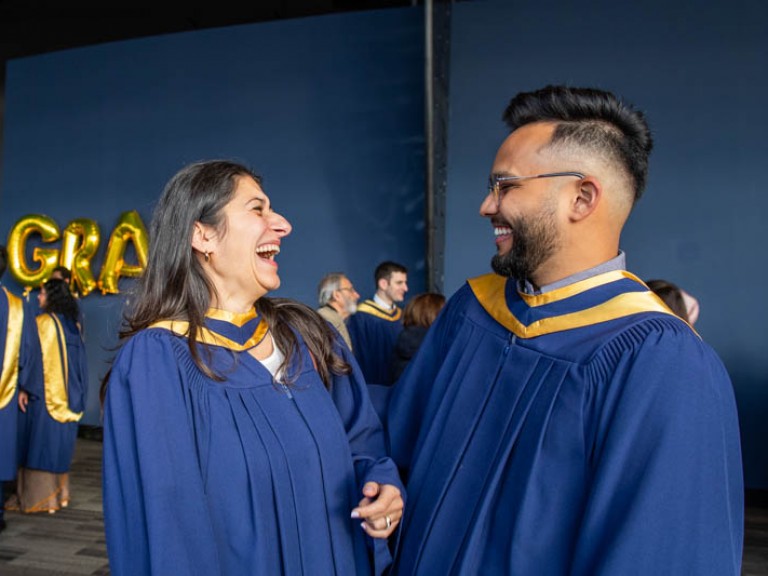 Two graduates smiling at each other