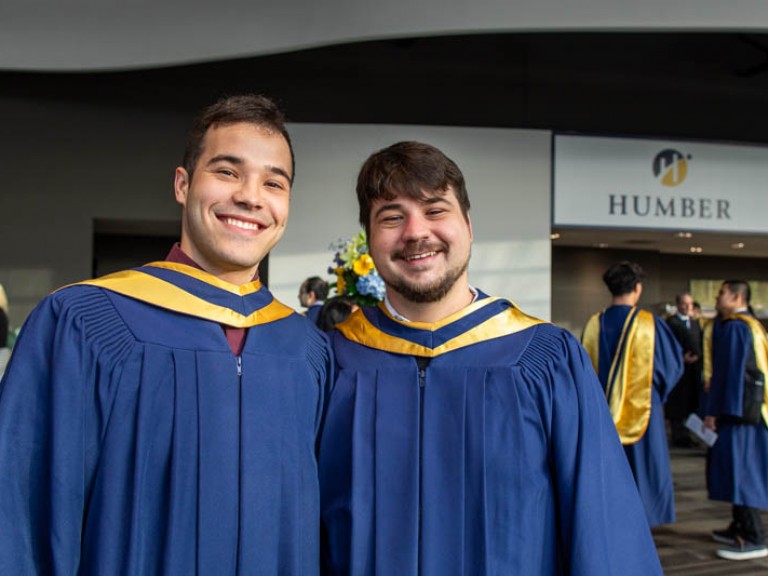 Two graduates smiling at camera