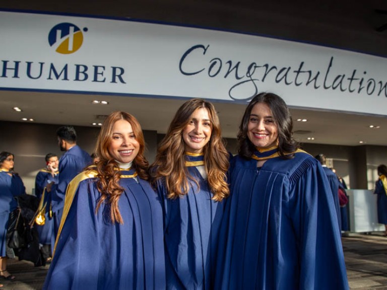 Three graduates smiling for photo