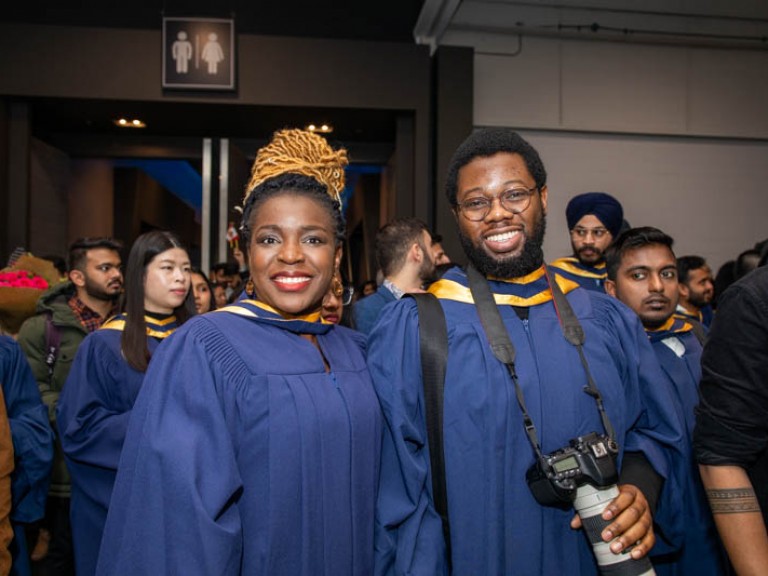 Two graduates smile for photo