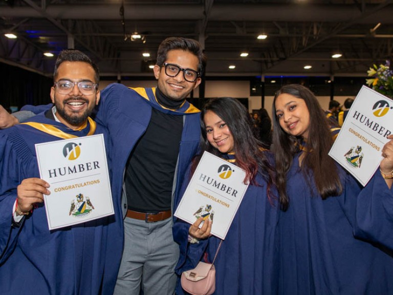 Four graduates pose for photo