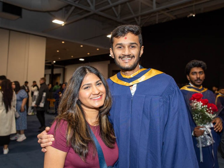 Graduate poses with guest for photo