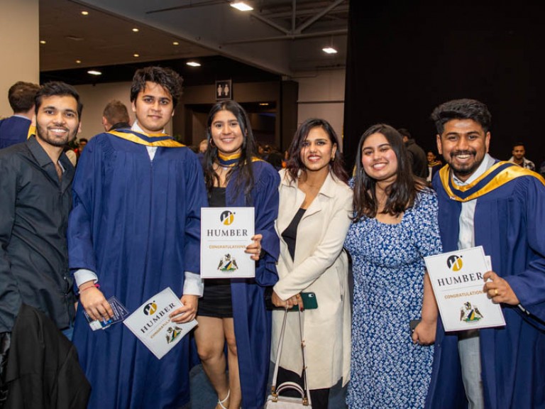 Three graduates pose with three ceremony guests for photo