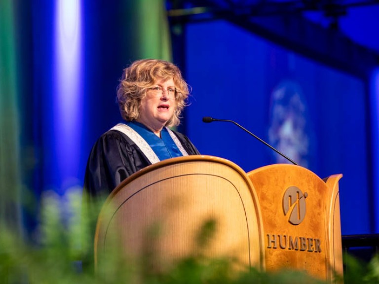 Humber president Ann Marie Vaughan speaking into podium microphone