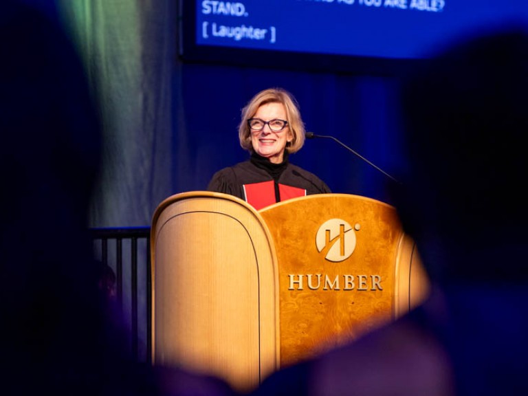 Dean of Business smiling behind podium