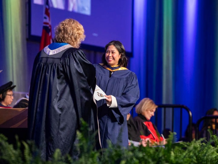 Graduate on stage smiles at Ann Marie Vaughan