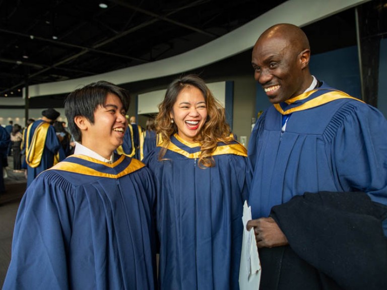 Three graduates laughing together