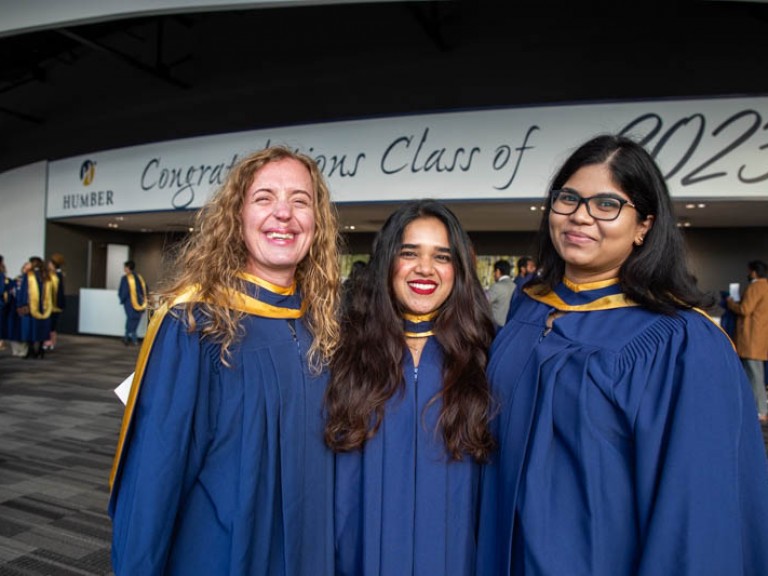 Three graduates smile for photo