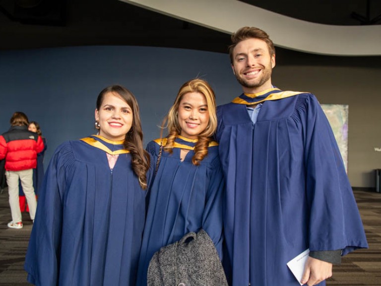 Three graduates pose for photo