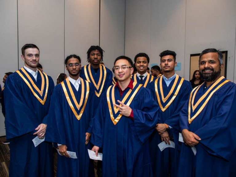 Seven graduates pose for photo