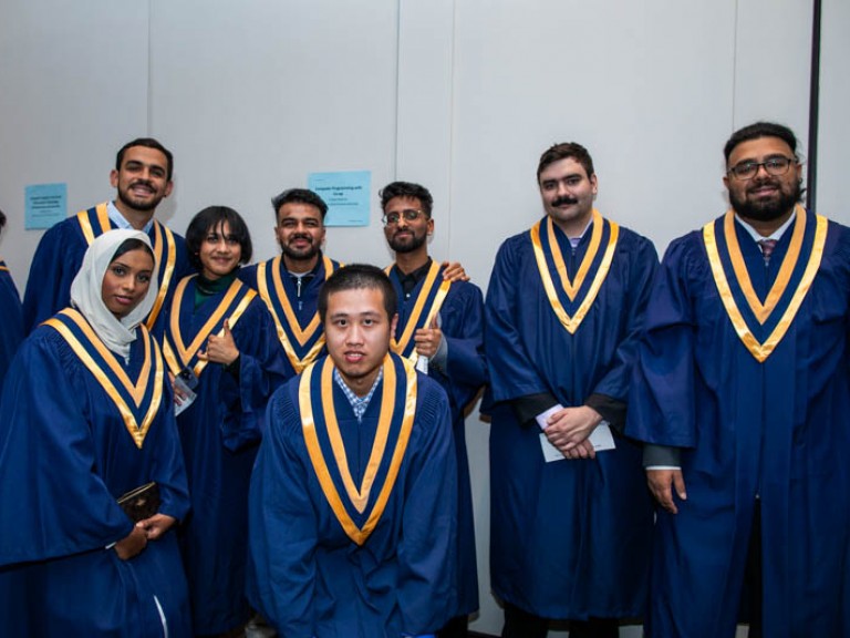 Eight graduates pose for photo