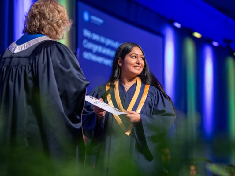 Graduate on stage accepts certificate