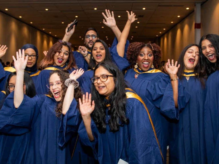 Ten graduates raise arms in celebration