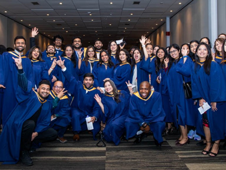 Large group of graduates pose in celebration