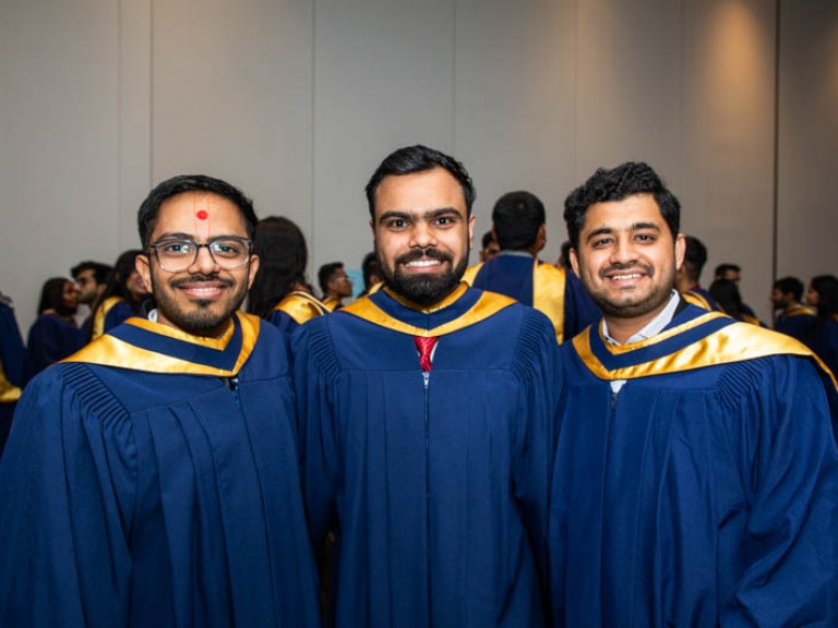 Three graduates pose for camera