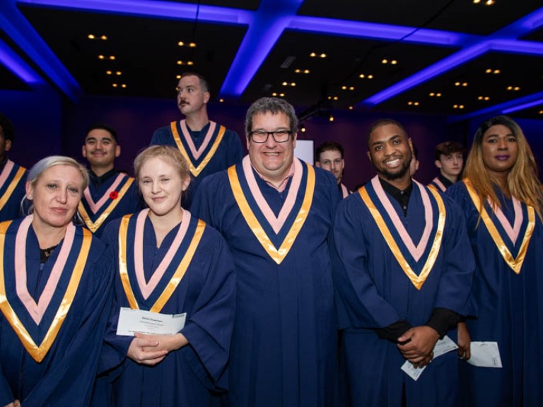 Eight graduates pose in the ceremony hall