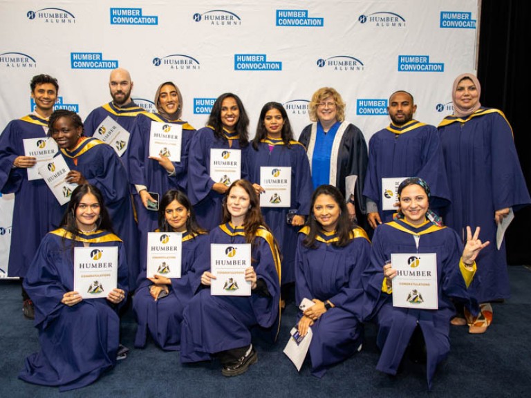 Group of graduates pose for photo with Humber president