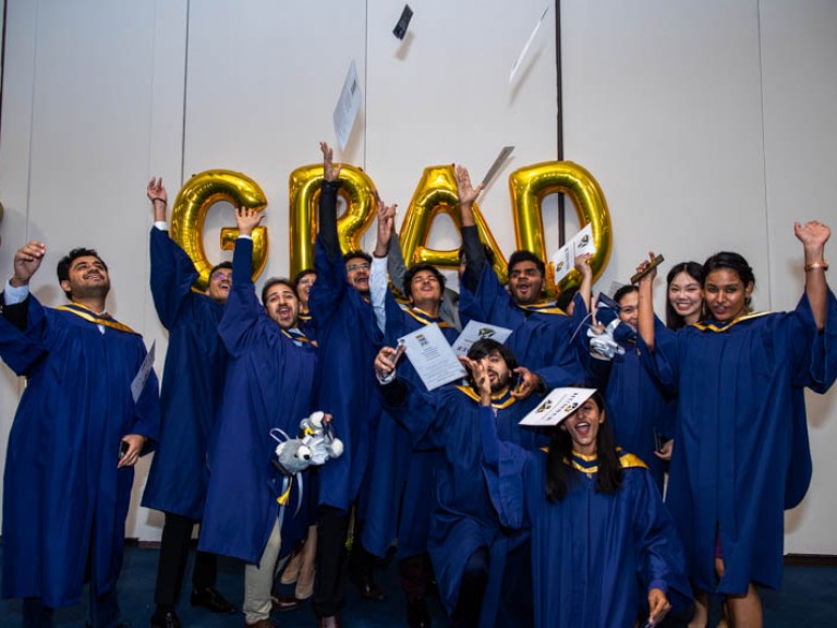 Graduates throw certificates in the air in celebration