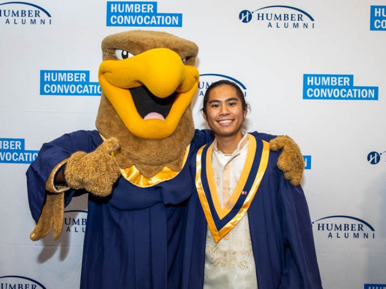 Graduate takes photo with Humber mascot