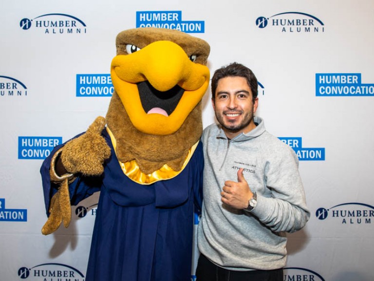 Humber mascot takes photo with person