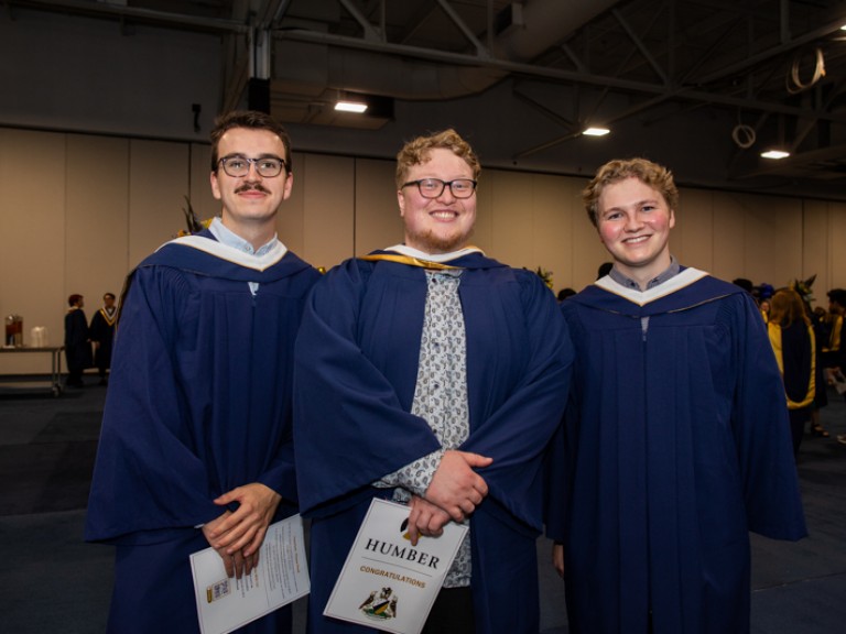 Three graduates smile for photo