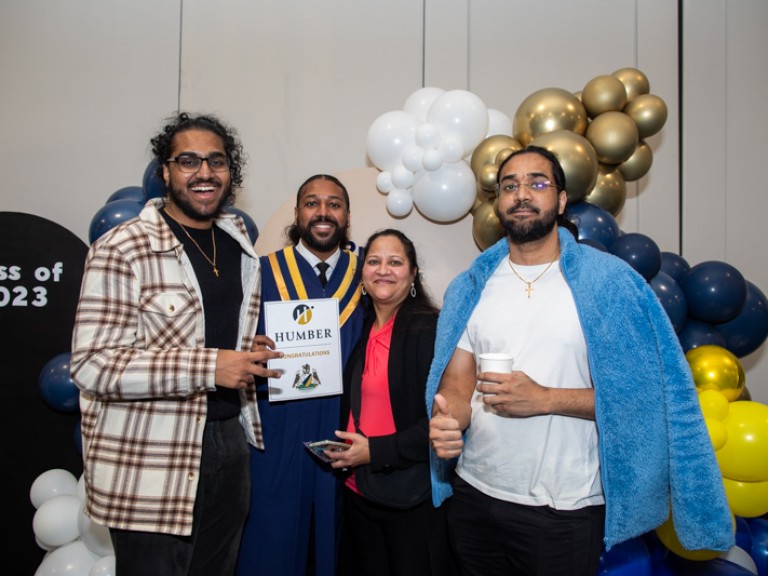 Graduate takes photo with three family members