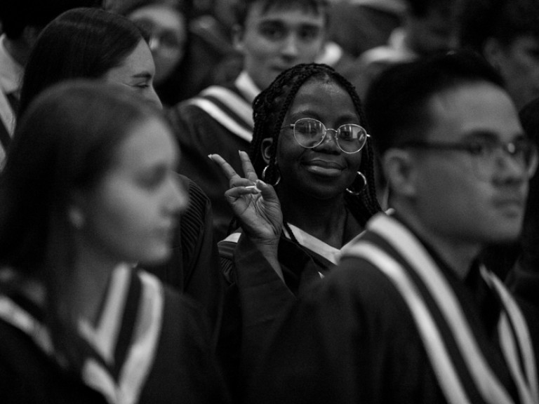 Graduate in audience makes peace sign 