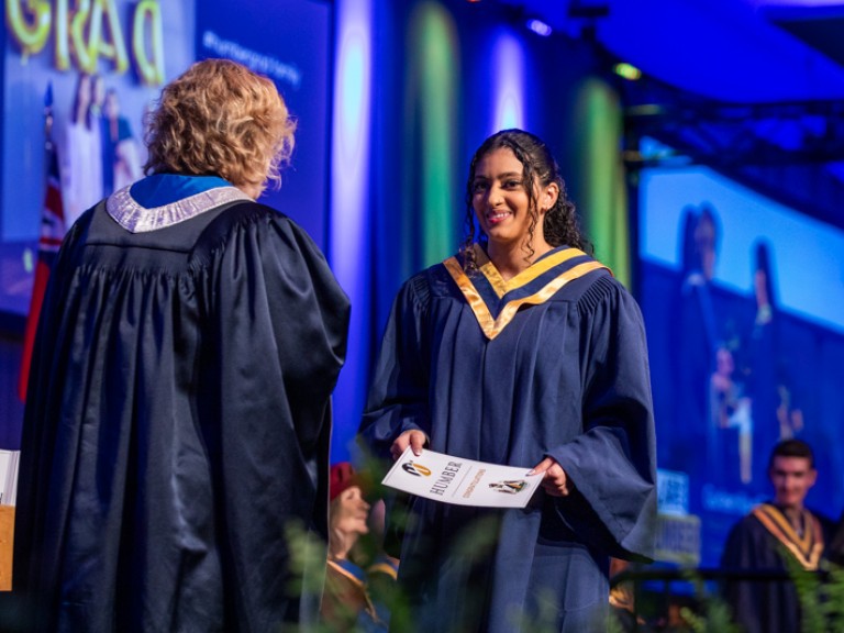 Graduate on stage with Ann Marie Vaughan