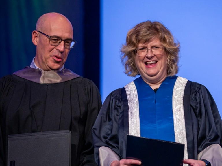 Humber president Ann Marie Vaughan smiles with faculty member on stage