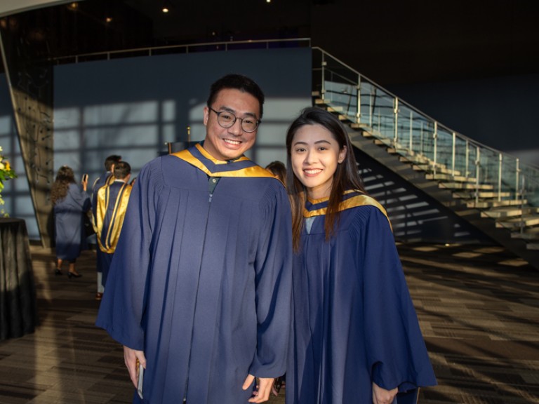 Two graduates smiling