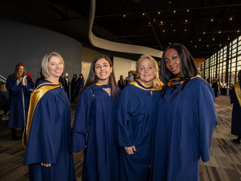 Four graduates pose for photo