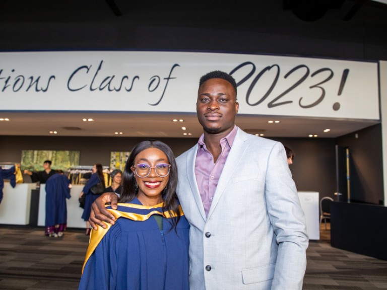 Graduate takes photo with ceremony guest