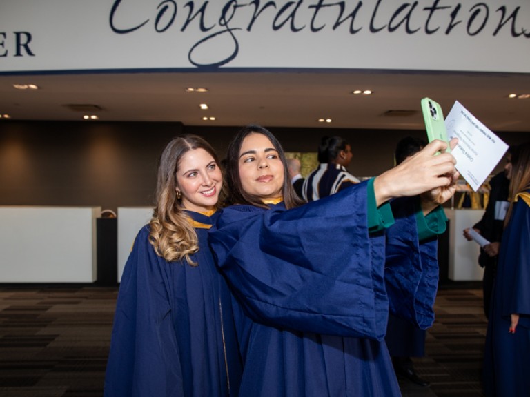 Two graduates take selfie together