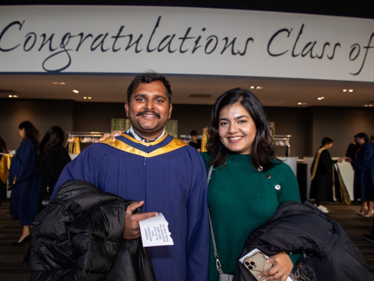Graduate poses for photo with ceremony guest