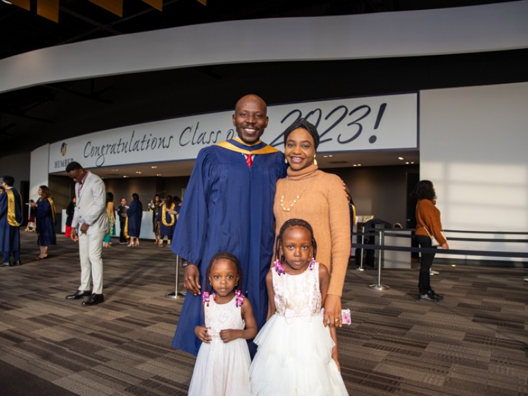 Graduate poses for photo with three family members