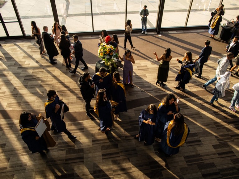 Bird's eye view of graduates mingling in ceremony reception area