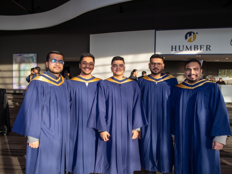 Five graduates posing for camera