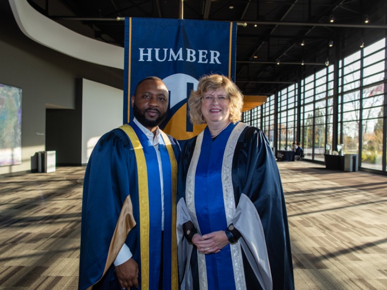 Ann Marie Vaughan takes photo with person in ceremonial robes