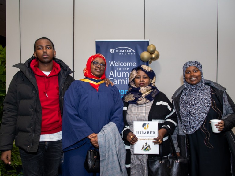 Graduate takes photo with three family members