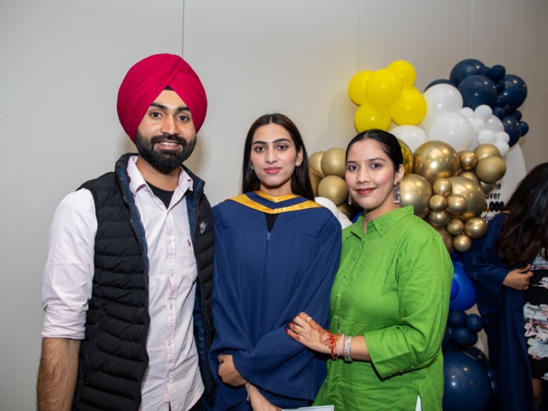 Graduate takes photo with two guests