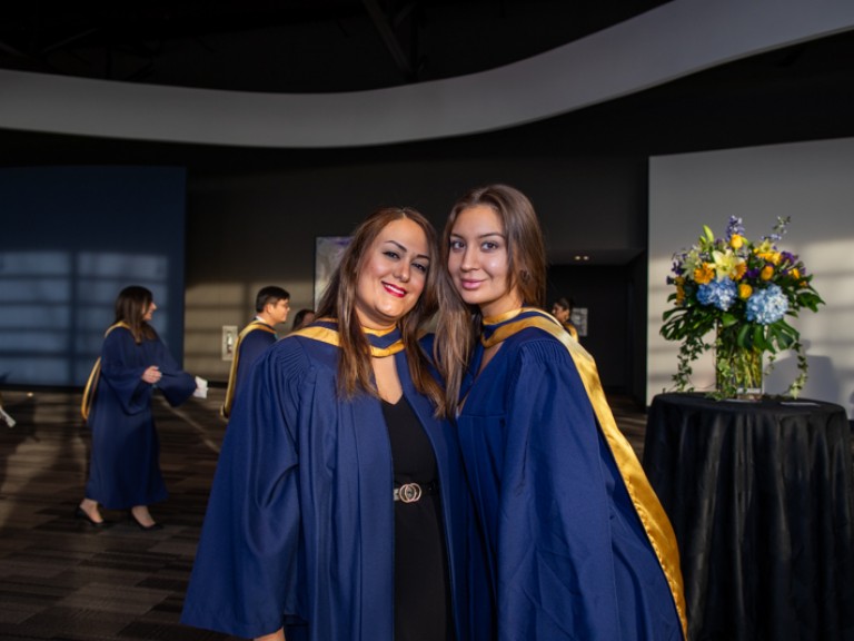 Two graduates posing for photo