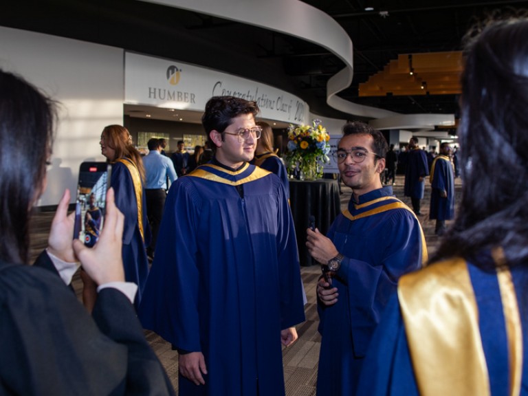 Person takes a cell phone picture of a graduate