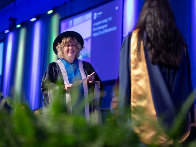 Ann Marie Vaughan smiles at graduate on stage