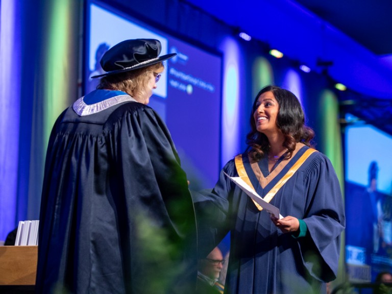 Graduate smiles at Ann Marie Vaughan on stage