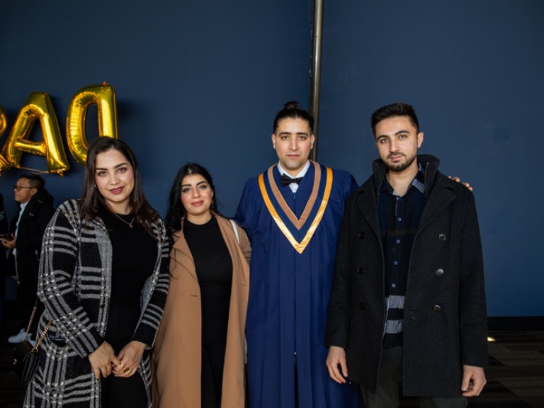 Graduate takes photo with three guests