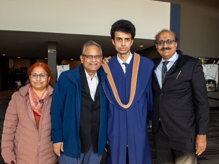 Graduate poses for photo with family