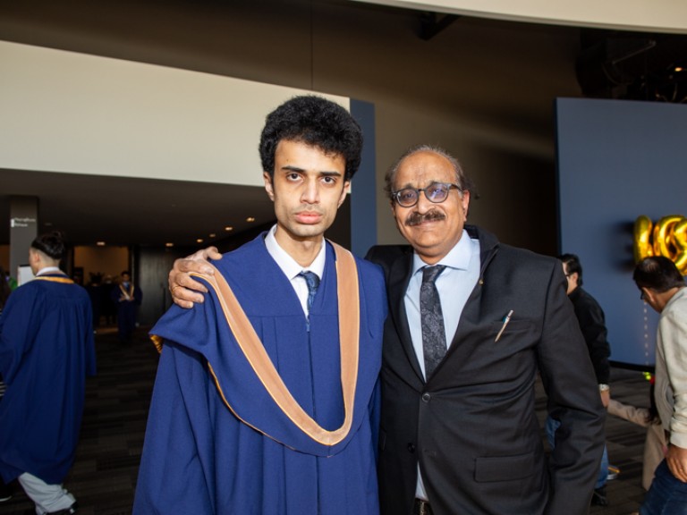 Graduate poses for photo with their father