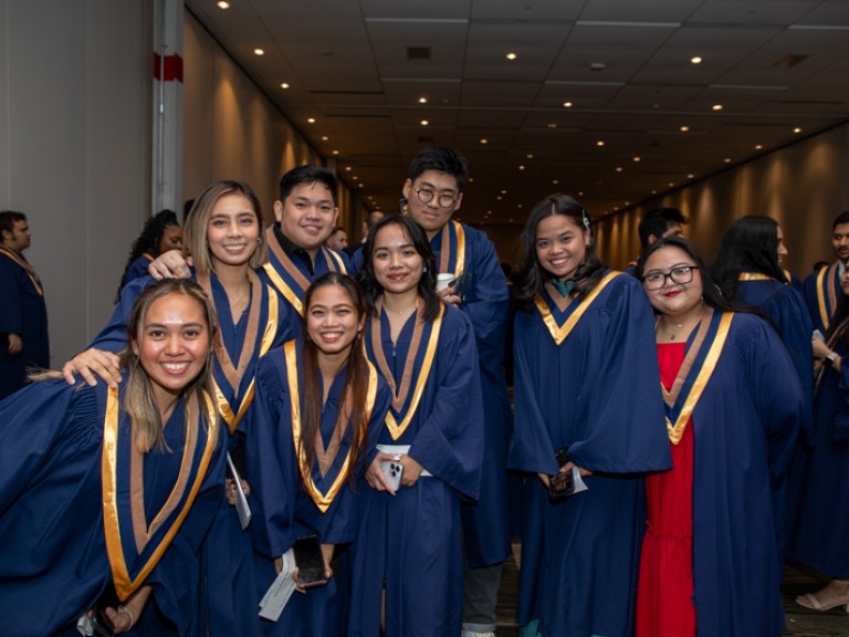 Eight graduates smile for photo