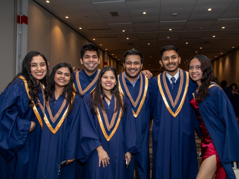 Seven graduates smile for photo