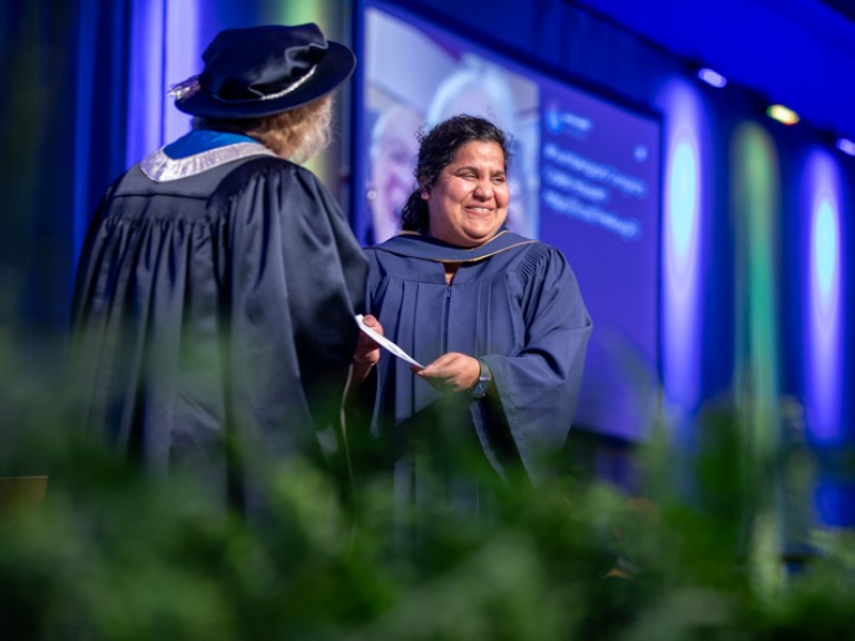 Graduate accepts certificate on stage